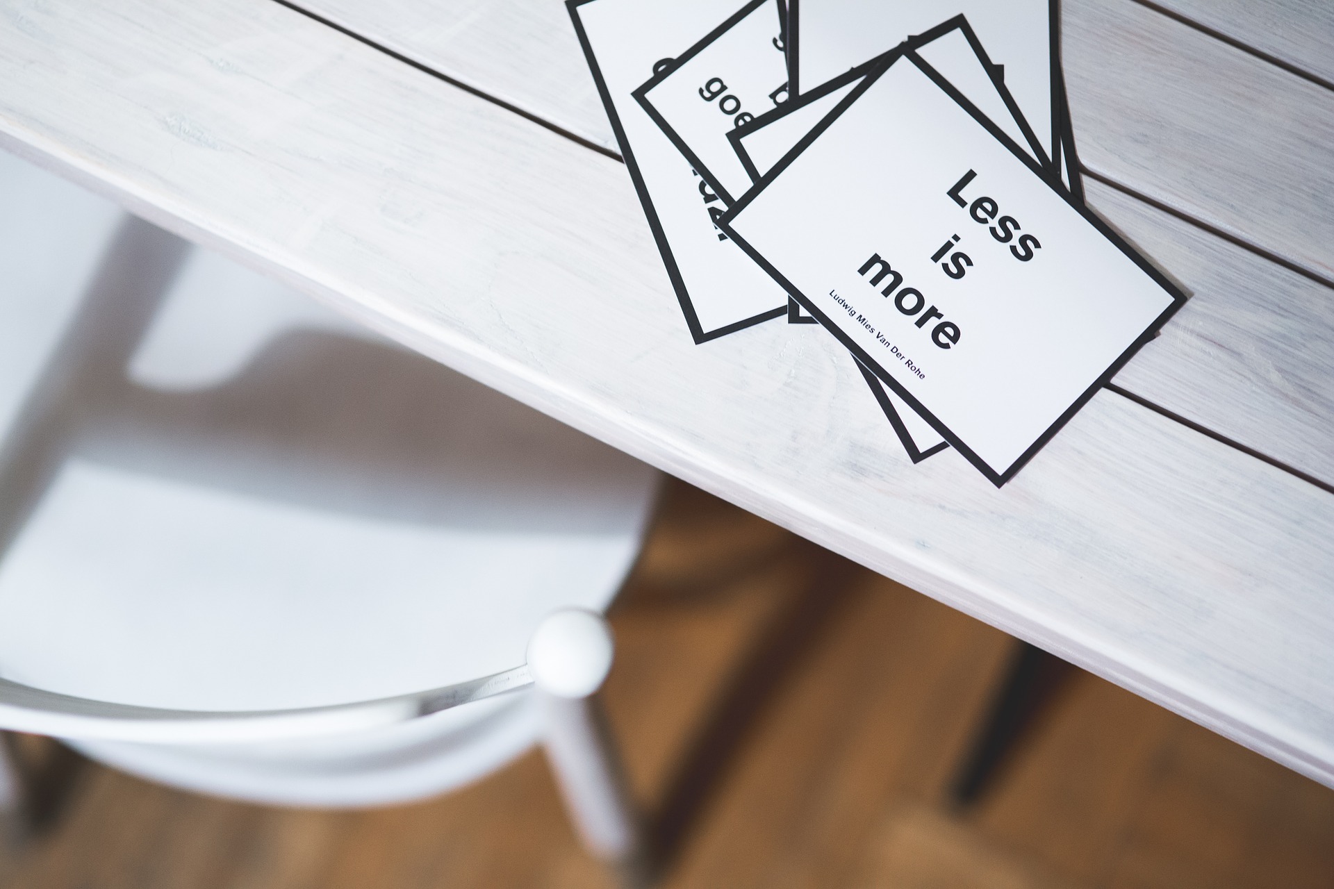 how to write concisely. A white desk, with small notlets that read "less is more".